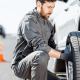 Mobile tire service technician changing a flat tire on the roadside