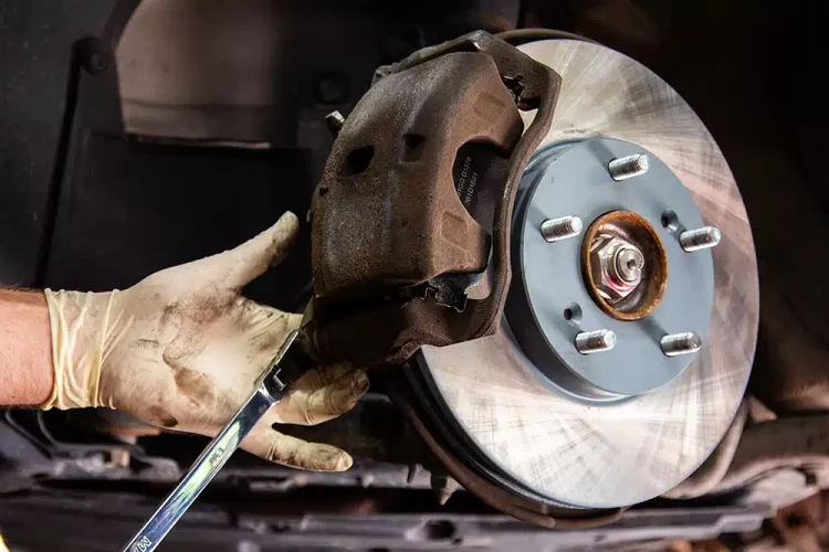 Mechanic performing a brake inspection and brake repair on a car at an auto repair shop