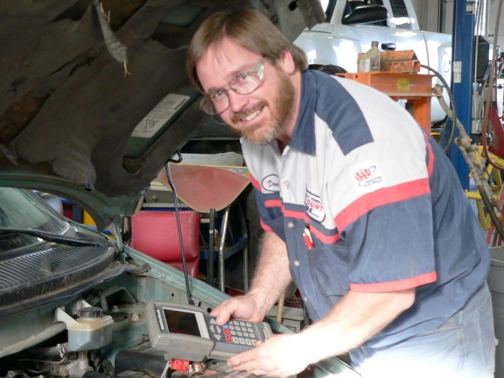 dennis our mechanic smiling under the hood